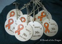 group of 8 round wooden ornaments featuring orange ribbon and 'in memory of Allie'